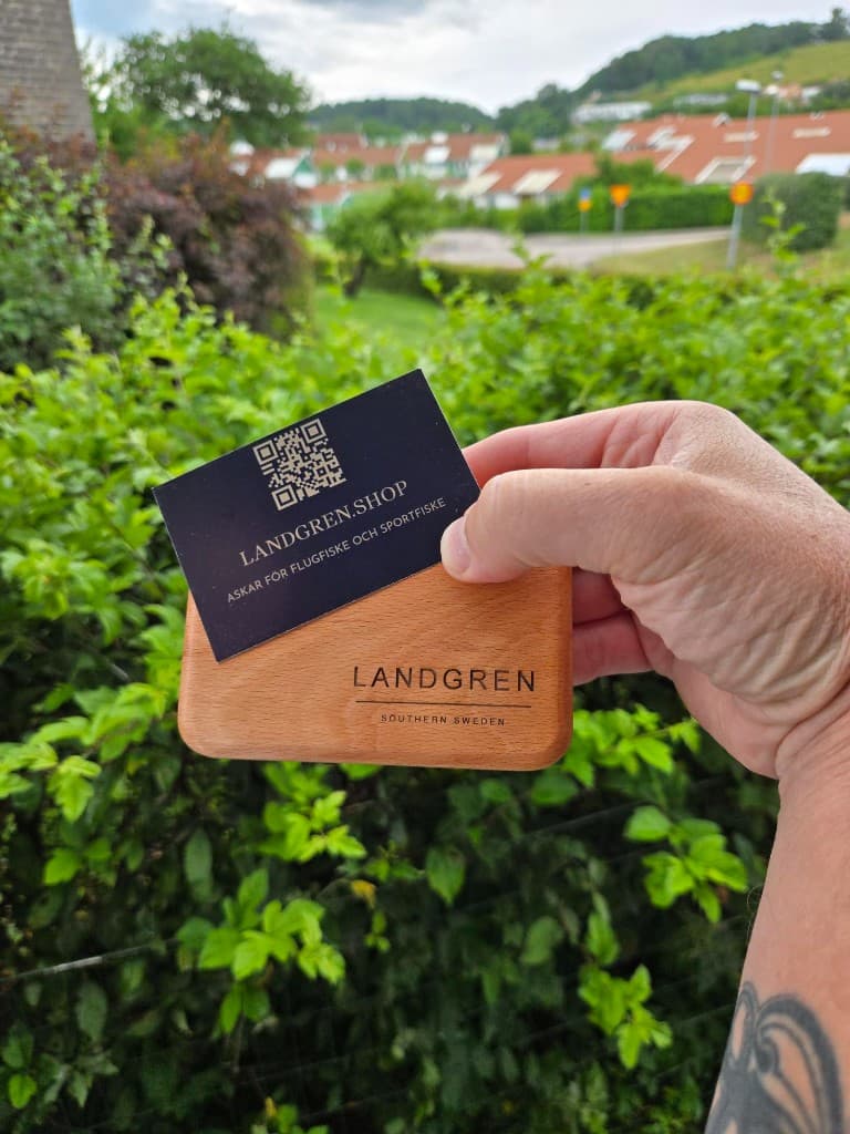 Hand som håller en stängd Landgren-ask i bokträ